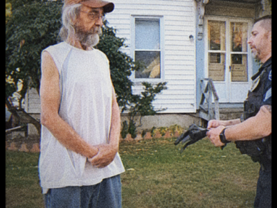 The first officer thought the woman standing barefoot in the driveway was a survivor. She kept asking whether her parents were alive, even though no one had told her where they had been found. Then a detective noticed something stranger: the emergency call that brought police to the house had come from a phone the woman insisted she had not touched all night. By sunrise, the question was no longer who had broken in. It was who had needed police to believe someone had.